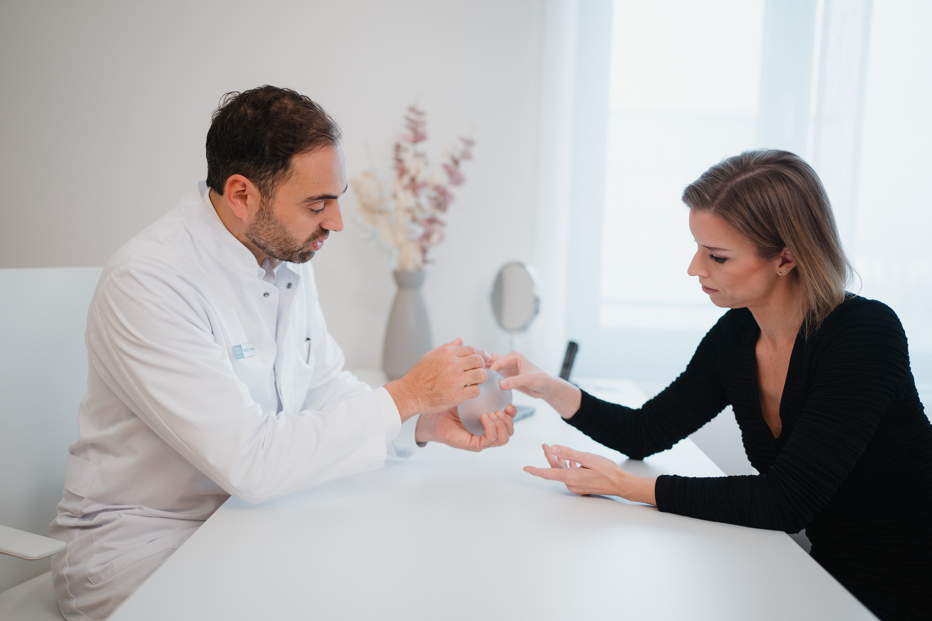 Prof. Penna aus der Klinik für plastische Chirurgie in Freiburg berät eine Patientin im Rahmen einer Zweitmeinung zur Brust und erklärt anhand eines Brustimplantats
